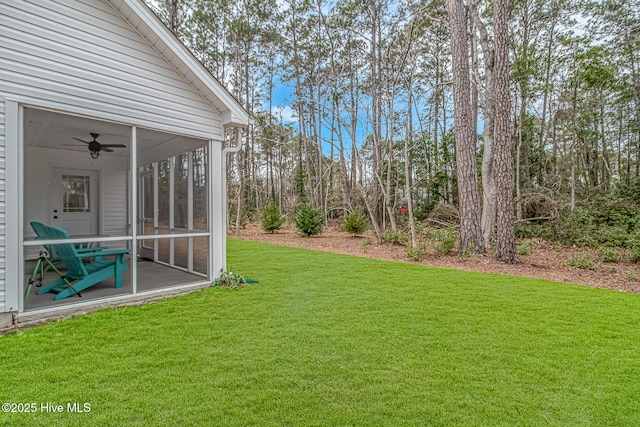 view of yard featuring a sunroom and ceiling fan