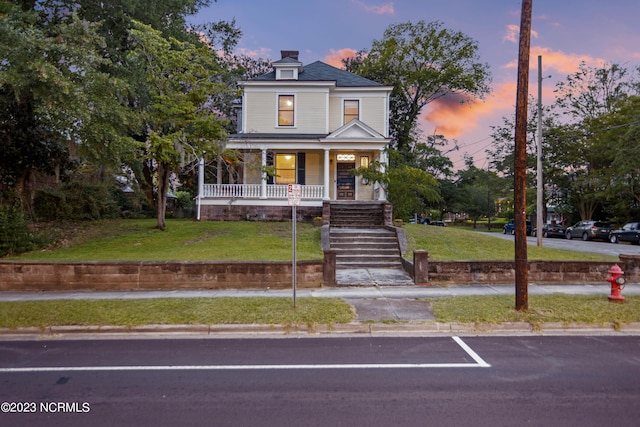 view of front of property featuring a yard and a porch