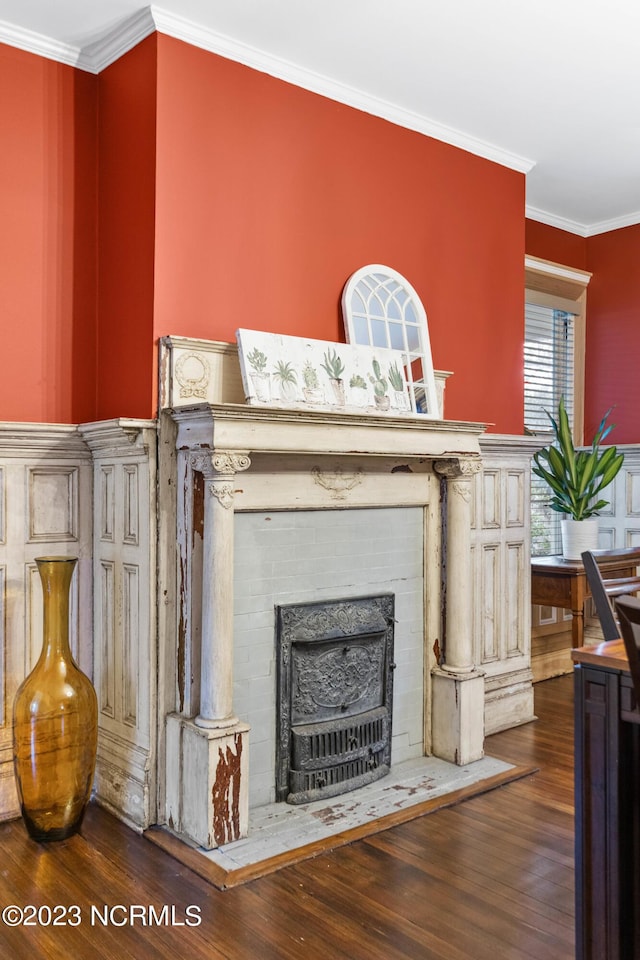 interior details with crown molding, wood finished floors, and a fireplace