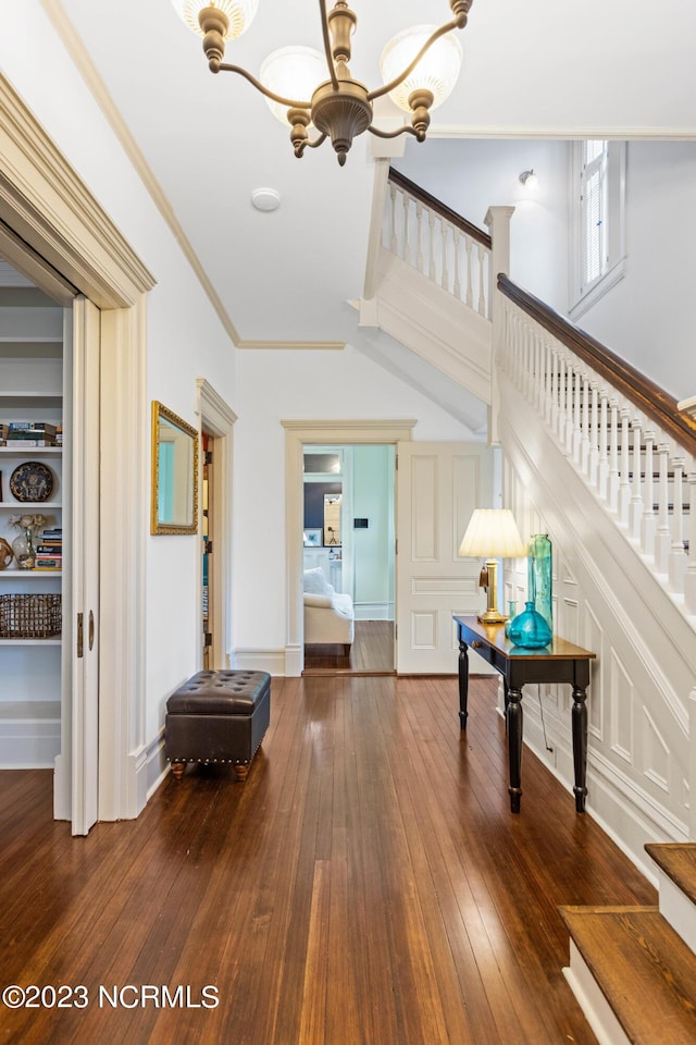 interior space featuring dark wood-type flooring, a chandelier, and ornamental molding