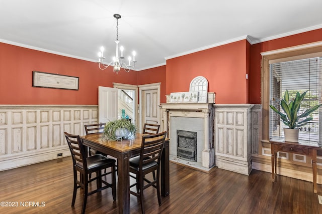 dining space with crown molding, a notable chandelier, wood finished floors, and a fireplace