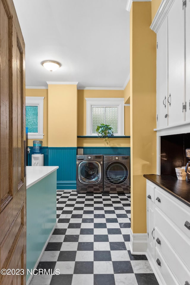 laundry room with crown molding, independent washer and dryer, a wealth of natural light, and dark floors