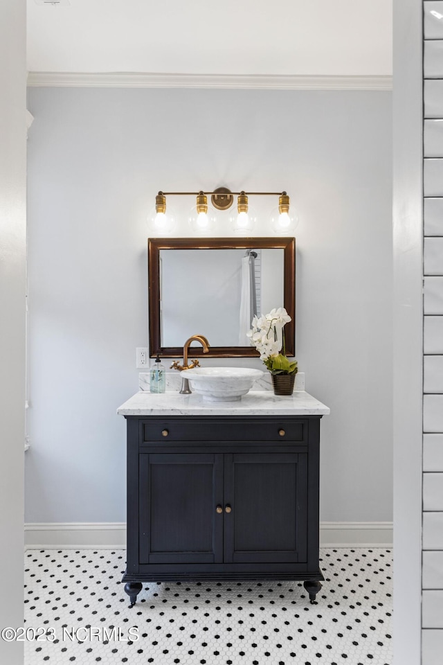 bathroom featuring crown molding, baseboards, and vanity