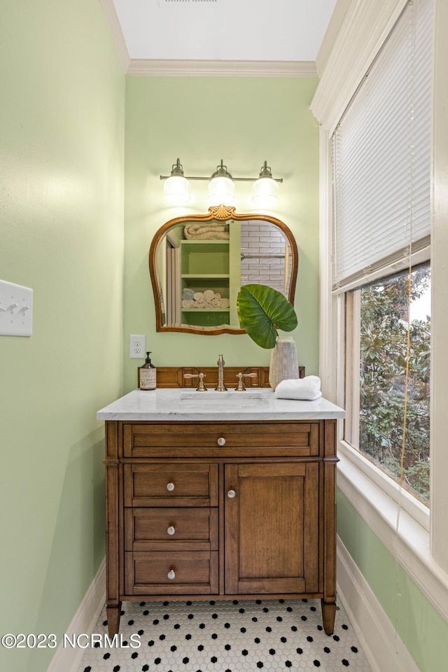 bathroom featuring baseboards, ornamental molding, and vanity