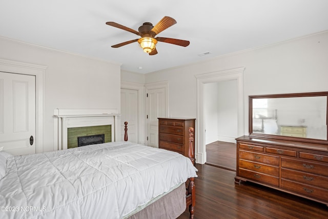 bedroom featuring visible vents, ornamental molding, ceiling fan, and dark wood-style floors