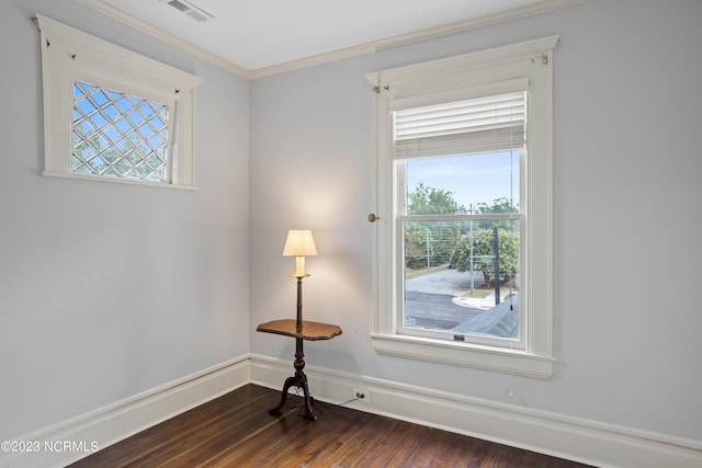unfurnished room featuring crown molding, visible vents, plenty of natural light, and dark wood finished floors