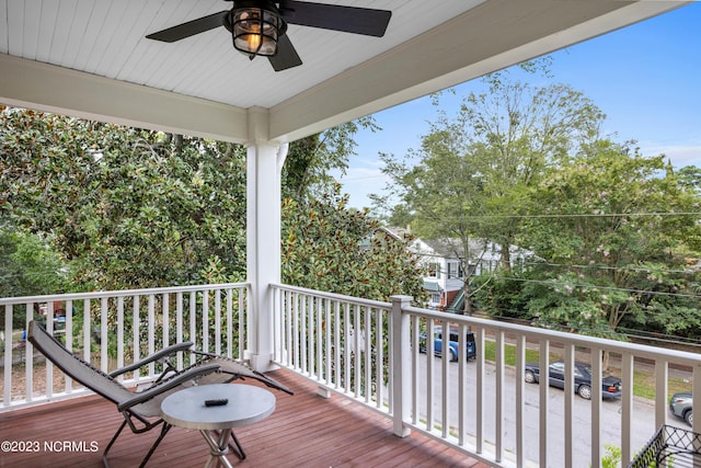 wooden terrace featuring covered porch and ceiling fan