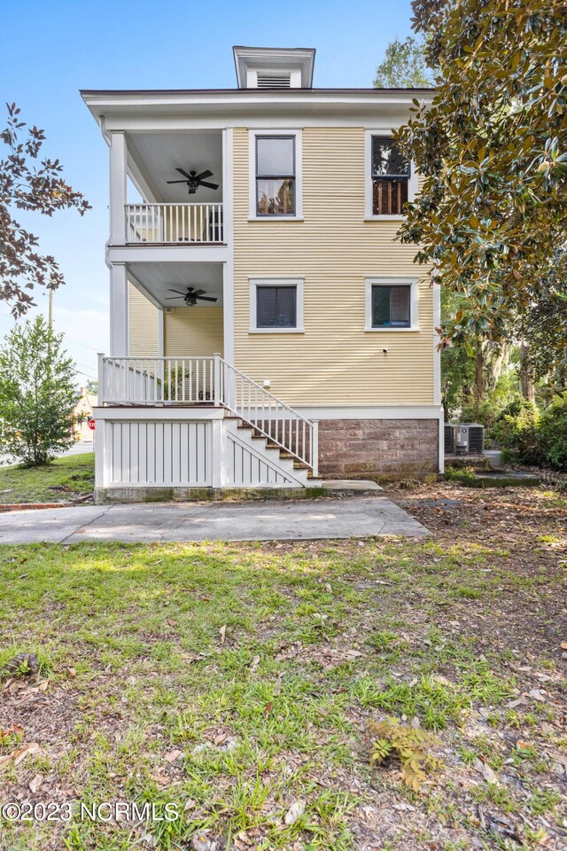 view of front of home with stairs, ceiling fan, central AC, and a front yard