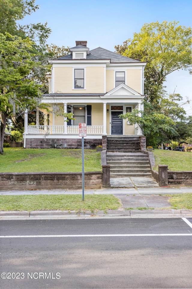 view of front of property with a porch and a front lawn