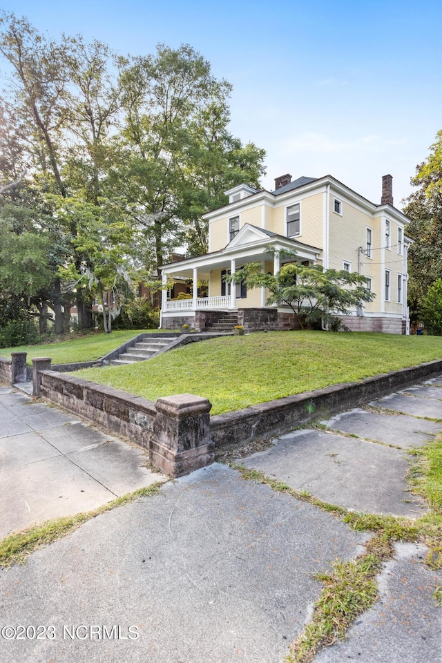 view of front of house featuring a front lawn and covered porch