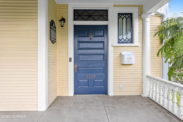 property entrance featuring a garage and a porch