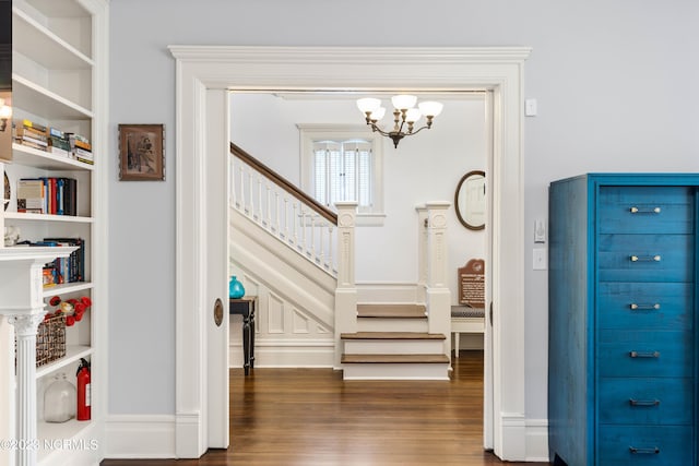 entrance foyer featuring stairway, wood finished floors, and a notable chandelier