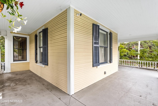 view of side of home featuring covered porch