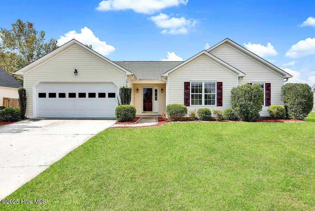 ranch-style home with a front lawn and a garage