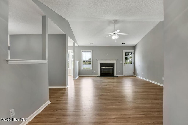 unfurnished living room with ceiling fan, wood-type flooring, and lofted ceiling