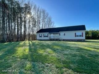 ranch-style house with a wooden deck and a front lawn