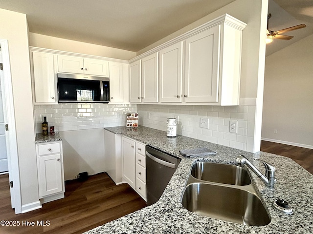 kitchen featuring white cabinetry, ceiling fan, appliances with stainless steel finishes, light stone counters, and sink