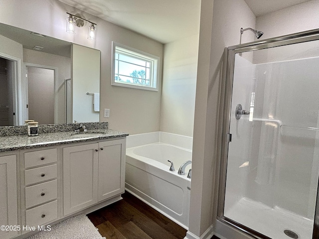 bathroom featuring vanity, plus walk in shower, and hardwood / wood-style floors