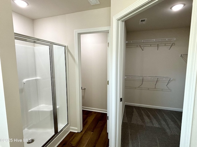 bathroom with wood-type flooring and a shower with door