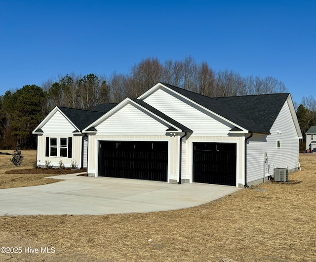 view of front of house featuring a garage and cooling unit