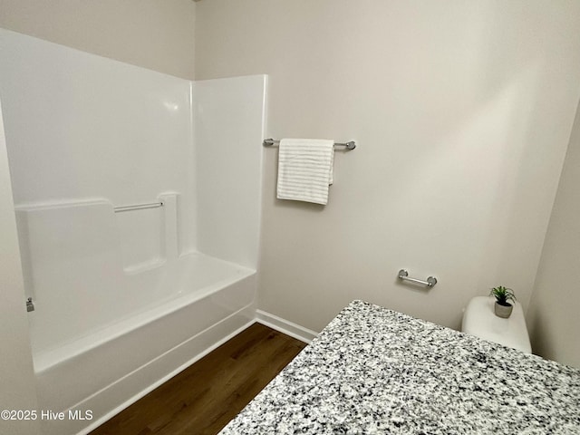 bathroom with toilet, tub / shower combination, and hardwood / wood-style floors