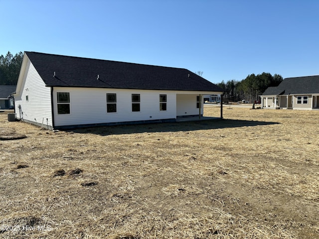 rear view of property featuring central AC and a yard