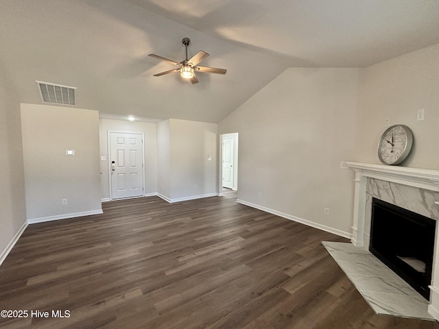 unfurnished living room with ceiling fan, dark wood-type flooring, a premium fireplace, and vaulted ceiling