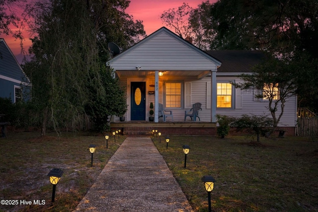 view of front of property with a lawn and a porch