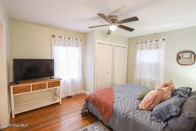 bedroom with ceiling fan, hardwood / wood-style floors, and a textured ceiling