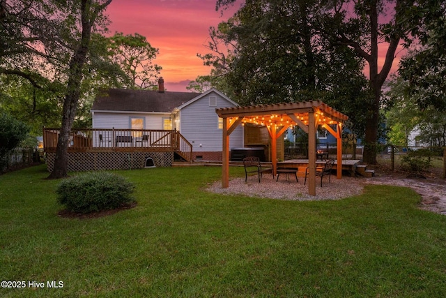 back house at dusk with a pergola, a deck, and a lawn