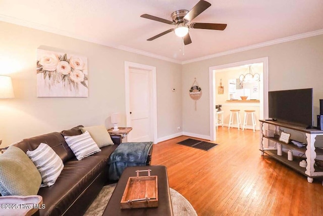 living room featuring ceiling fan, wood-type flooring, and ornamental molding