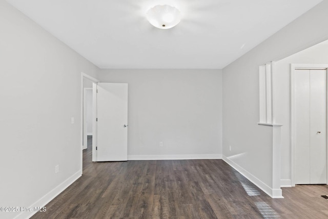 empty room with dark hardwood / wood-style flooring