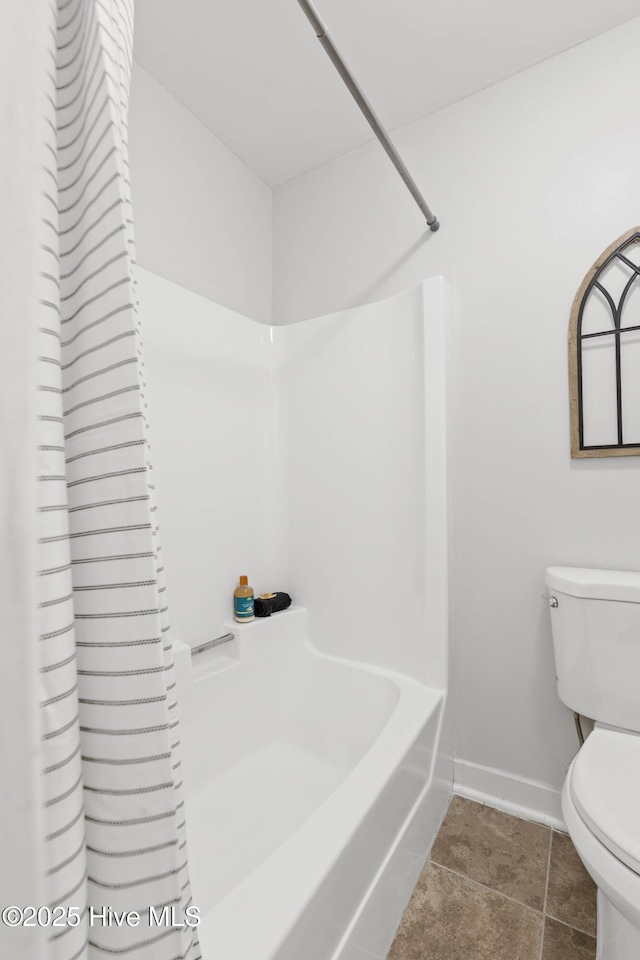 bathroom featuring toilet, shower / tub combination, and tile patterned floors