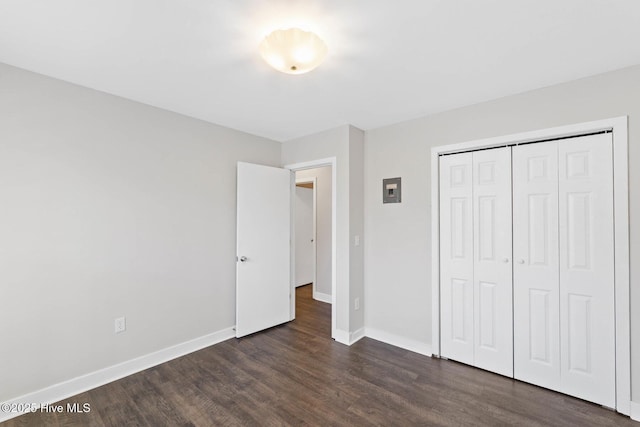 unfurnished bedroom with a closet and dark hardwood / wood-style flooring