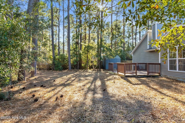 view of yard featuring a shed and a wooden deck