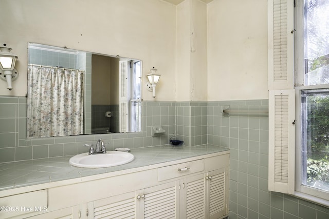 bathroom with vanity, tile walls, and curtained shower