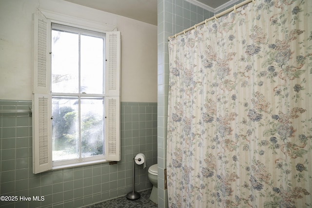 bathroom with tile patterned floors, tile walls, toilet, ornamental molding, and a shower with shower curtain