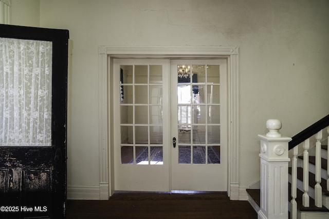 entryway with french doors, dark hardwood / wood-style flooring, and a notable chandelier