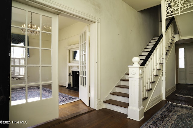 stairs with hardwood / wood-style flooring and a notable chandelier