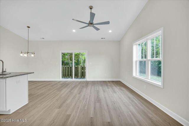 211 Lincoln Place Cir, Leland, NC 28451 - unfurnished living room with plenty of natural light, ceiling fan, light wood-style flooring, a sink, and vaulted ceiling
