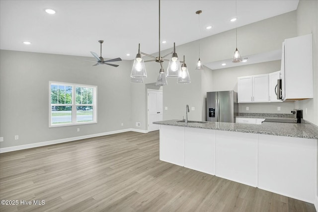 211 Lincoln Place Cir, Leland, NC 28451 - kitchen with appliances with stainless steel finishes, a sink, ceiling fan, light stone counters, and light wood finished floors
