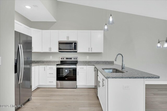 211 Lincoln Place Cir, Leland, NC 28451 - kitchen with stainless steel appliances, a sink, a peninsula, light stone countertops, and white cabinets