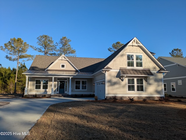 craftsman house with concrete driveway, metal roof, an attached garage, a standing seam roof, and a front lawn