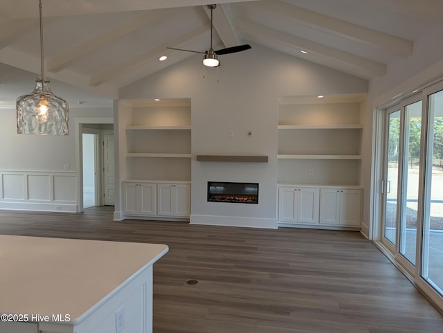 unfurnished living room featuring vaulted ceiling with beams, dark wood-style flooring, and a glass covered fireplace