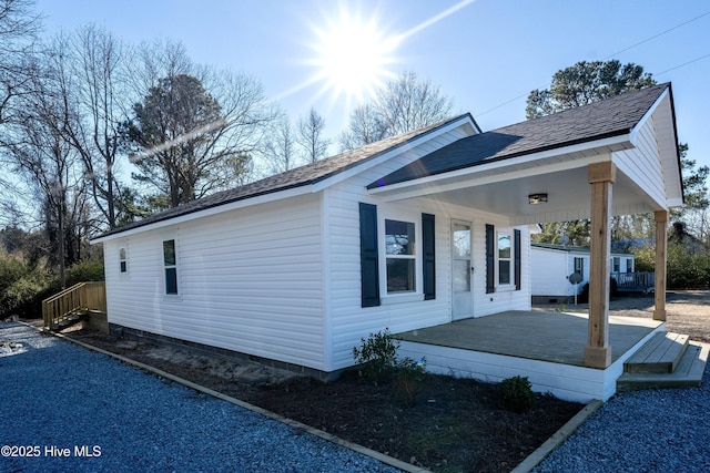 view of property exterior featuring a porch and roof with shingles