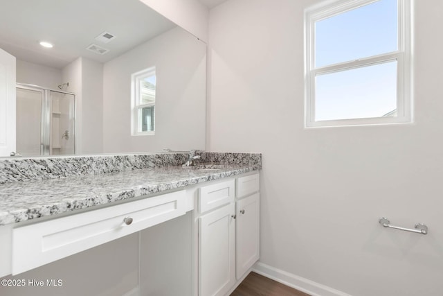 bathroom featuring walk in shower and vanity