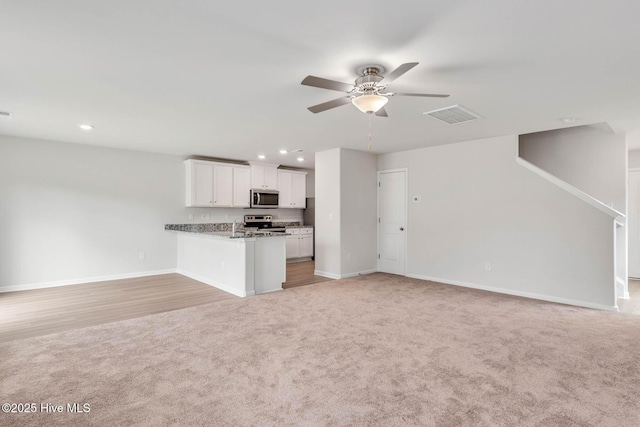 unfurnished living room with ceiling fan and light colored carpet