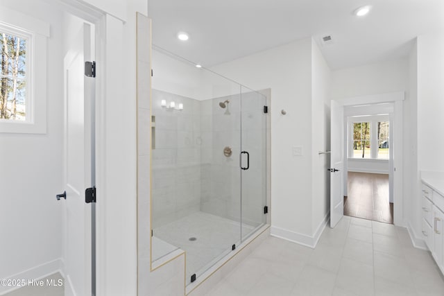 bathroom featuring a wealth of natural light, an enclosed shower, and vanity