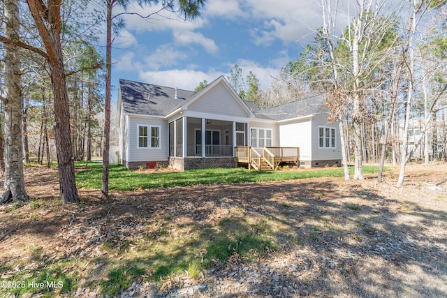 back of property featuring ceiling fan, a wooden deck, a sunroom, and a lawn