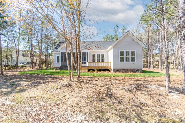 rear view of property featuring a deck and a yard